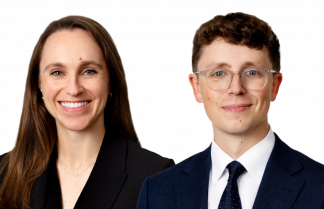 A brunette woman in a dark top and a man with dark hair and glasses.